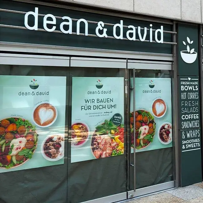 Schaufenstergrafik und Beschriftung an einer dean & david Filiale