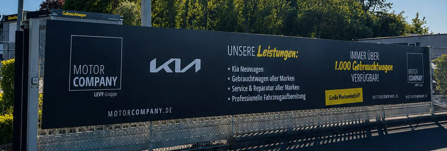Großformatiges Werbebanner an einer Autohaus-Einfriedung